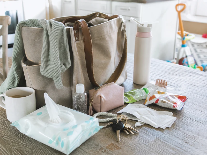 A realistic mom bag with practical daily essentials on a lived-in kitchen table